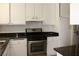 Kitchen featuring white cabinets, black countertops, and stainless steel appliances for a modern feel at 7170 Mountain Moss Dr, Las Vegas, NV 89147