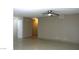 Open living room with tile flooring, neutral walls, ceiling fan, and access to other rooms at 7170 Mountain Moss Dr, Las Vegas, NV 89147