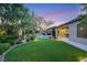 Beautiful backyard with a sparkling pool, lush landscaping, and artificial grass at 7181 Barton Creek Ct, Las Vegas, NV 89113
