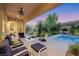 Inviting covered patio overlooking the pool and landscaped yard provides a perfect outdoor living space at 7181 Barton Creek Ct, Las Vegas, NV 89113