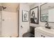Modern bathroom featuring a white vanity, black fixtures, and unique artwork on the walls at 7250 Diamond Canyon Ln # 204, Las Vegas, NV 89149