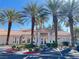 Community clubhouse surrounded by palm trees, parking, and well-manicured landscaping at 7450 S Eastern Ave # 1059, Las Vegas, NV 89123