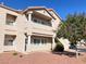 Tan condo building exterior with balconies, red rock landscaping, and a leafy green tree at 7450 S Eastern Ave # 1059, Las Vegas, NV 89123