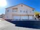 Rear exterior of the condo featuring white garage doors and balconies at 7450 S Eastern Ave # 1059, Las Vegas, NV 89123