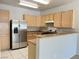 Bright kitchen with stainless steel refrigerator, granite countertops, and light wood cabinetry at 7450 S Eastern Ave # 1059, Las Vegas, NV 89123
