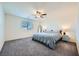 Spacious bedroom featuring a ceiling fan, plush carpet, and a bright window at 7605 Moore Creek Ln, North Las Vegas, NV 89084