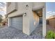 Home exterior featuring a two-car garage and front door entryway with brick paved driveway at 7605 Moore Creek Ln, North Las Vegas, NV 89084
