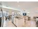Modern kitchen with stainless steel appliances and a granite-topped island overlooking the living area at 7605 Moore Creek Ln, North Las Vegas, NV 89084