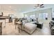 An open living space with neutral tones, a cozy sectional, and a kitchen in the background at 7605 Moore Creek Ln, North Las Vegas, NV 89084