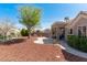 Private backyard boasting low-maintenance desert landscaping, a covered patio, and mature trees at 8812 Marble Dr, Las Vegas, NV 89134