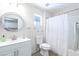 Cozy bathroom features a vanity with a round mirror and a shower with a decorative white curtain at 8812 Marble Dr, Las Vegas, NV 89134