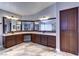 Spacious bathroom featuring a granite countertop, double sinks, dark wood cabinetry, and a large mirror at 8944 Campanella St, Las Vegas, NV 89123