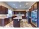 Gourmet kitchen featuring stainless steel appliances, granite countertops, a center island, and dark wood cabinetry at 8944 Campanella St, Las Vegas, NV 89123