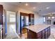 Open kitchen with island, stainless steel appliances, dark wood cabinets, and tile flooring at 8944 Campanella St, Las Vegas, NV 89123