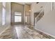 Spacious living room with high ceilings, tile flooring, a staircase, and large windows filling the space with light at 8944 Campanella St, Las Vegas, NV 89123