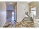 Hallway with tile flooring leads to a staircase and bright living room featuring high ceilings and large windows at 8944 Campanella St, Las Vegas, NV 89123