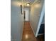 Narrow hallway featuring hardwood floors and neutral wall paint leading to a white door at 898 Flagstone Way, Las Vegas, NV 89110