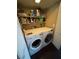 Functional laundry room with front-load washer and dryer, complemented by shelving for storage at 898 Flagstone Way, Las Vegas, NV 89110