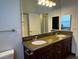 Bathroom featuring double sinks with granite countertops and dark wood cabinets at 8985 S Durango Dr # 1010, Las Vegas, NV 89113