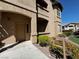 Exterior view of a condo with a beige door, walkway, and neat landscaping at 8985 S Durango Dr # 1010, Las Vegas, NV 89113