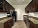 Galley kitchen featuring rich wood cabinetry, granite countertops and stainless steel appliances at 8985 S Durango Dr # 1010, Las Vegas, NV 89113
