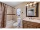 Bathroom with tile surround, vanity, decorative mirror, and a shower with curtain at 902 Dianne Dr, Boulder City, NV 89005