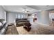 A living room featuring a leather couch, ceiling fan, and an open view into the kitchen at 902 Dianne Dr, Boulder City, NV 89005