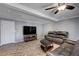 Spacious living room with a leather couch, ceiling fan, and a large screen TV on a wooden stand at 902 Dianne Dr, Boulder City, NV 89005
