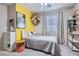 Charming bedroom with ceiling fan, yellow accent wall, and ample natural light at 9066 Hilverson Ave, Las Vegas, NV 89148