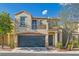 Charming two-story home featuring a blue garage door and a second-story balcony at 9066 Hilverson Ave, Las Vegas, NV 89148