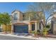 Charming two-story home featuring a blue garage door and a second-story balcony at 9066 Hilverson Ave, Las Vegas, NV 89148
