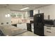 Modern kitchen features black appliances, white cabinetry, gray countertops, and stylish pendant lighting at 928 Rockview Dr # 102, Las Vegas, NV 89128