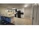 Spacious kitchen features white cabinets, black appliances, island with bar seating, and tile flooring at 928 Rockview Dr # 102, Las Vegas, NV 89128