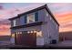 Charming two-story home with a brown garage door, gray paint and a beautiful sunset at 9671 S Conquistador St # Lot 18, Las Vegas, NV 89178