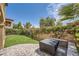 A backyard is landscaped with artificial turf, a paver patio, brick walls, and lush greenery at 11913 Alava Ave, Las Vegas, NV 89138