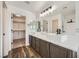 Bathroom with double sink vanity, modern lighting, and walk-in closet access at 11913 Alava Ave, Las Vegas, NV 89138