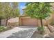 Inviting two-story home featuring a tile roof, tan stucco, a two-car garage, and drought tolerant landscaping at 11913 Alava Ave, Las Vegas, NV 89138