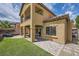 An exterior home elevation shows a covered patio, a balcony, manicured artificial grass, and a paver patio at 11913 Alava Ave, Las Vegas, NV 89138