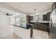 Bright kitchen featuring modern stainless steel appliances, a kitchen island, and adjacent open living space at 11913 Alava Ave, Las Vegas, NV 89138
