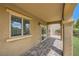 A covered patio offers privacy with neutral tones, a paver patio, a window, and a sliding glass door at 11913 Alava Ave, Las Vegas, NV 89138