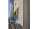 Condo exterior with stucco facade, blue metal staircase and railing under bright blue sky at 2725 S Nellis Blvd # 2083, Las Vegas, NV 89121