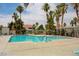 Large community swimming pool with surrounding palm trees, lounge chairs, and lush landscaping at 2725 S Nellis Blvd # 2083, Las Vegas, NV 89121