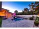 Spacious backyard features a sparkling pool, a stone patio, and lush landscaping for serene outdoor living at 3008 Astoria Pines Cir, Las Vegas, NV 89107