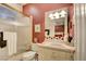 The bathroom has shower-bath combo, a dark red wall, and pink toilet and sink at 3008 Astoria Pines Cir, Las Vegas, NV 89107