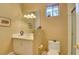 Cozy bathroom with a sink, toilet, and tiled shower, bathed in natural light from a small window at 3008 Astoria Pines Cir, Las Vegas, NV 89107