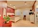 Spacious bedroom with a decorative ceiling, red accent wall, and light hardwood floors at 3008 Astoria Pines Cir, Las Vegas, NV 89107