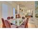 Bright dining room with glass table and seating for six under recessed lighting with white shuttered windows at 3008 Astoria Pines Cir, Las Vegas, NV 89107