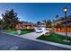 Charming exterior view features a well-manicured lawn, a white car, and an attached two-car garage at 3008 Astoria Pines Cir, Las Vegas, NV 89107
