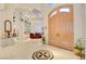 Bright entryway featuring marble floors, arched doors, and a dining room with a glass display case at 3008 Astoria Pines Cir, Las Vegas, NV 89107