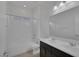 Bright bathroom featuring double sinks with black cabinetry, a full mirror, and a shower-tub combo at 5589 Pico Ferrera Ct, Las Vegas, NV 89113
